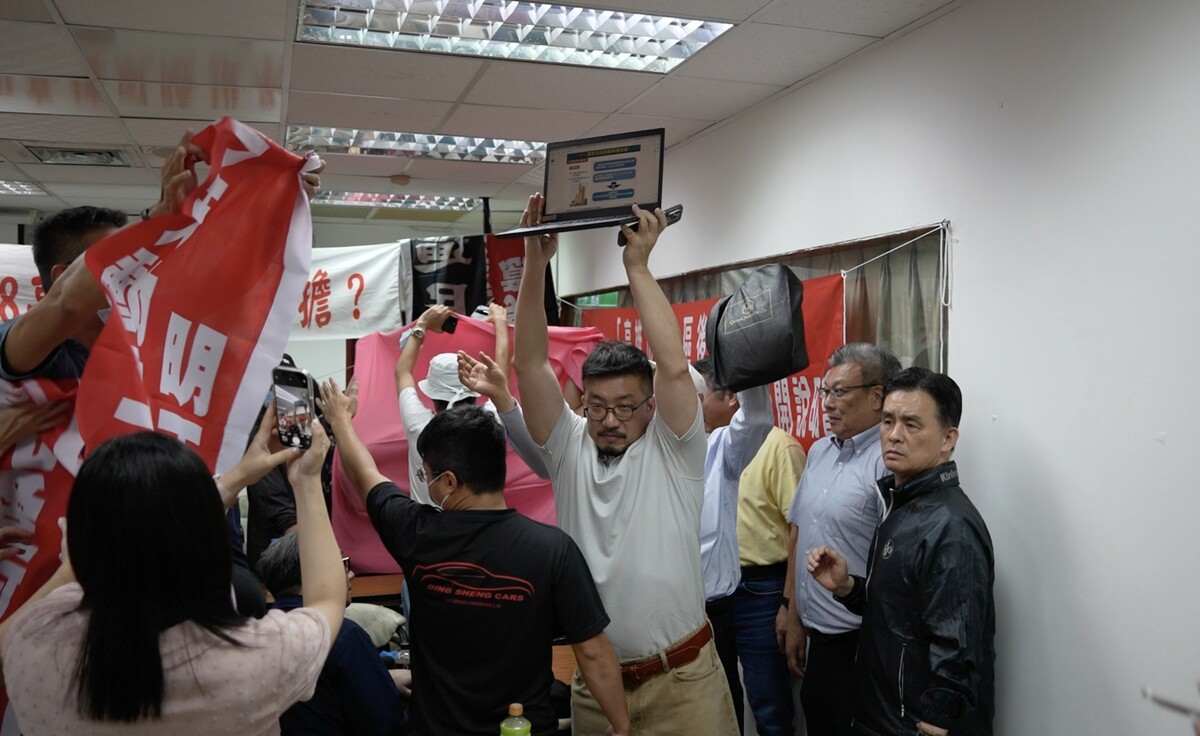 大陸工程人員在一片混亂中高舉電腦，以示宣達效果。 圖：陳麗娜服務處/提供