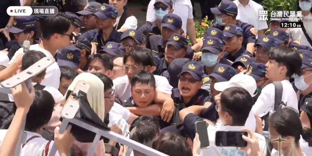 警方表示，黃國昌不斷鼓動民眾前進、推擠員警及阻材，進而攀越阻材，已違反集會遊行法等規定。 圖：取自民眾之聲YouTube