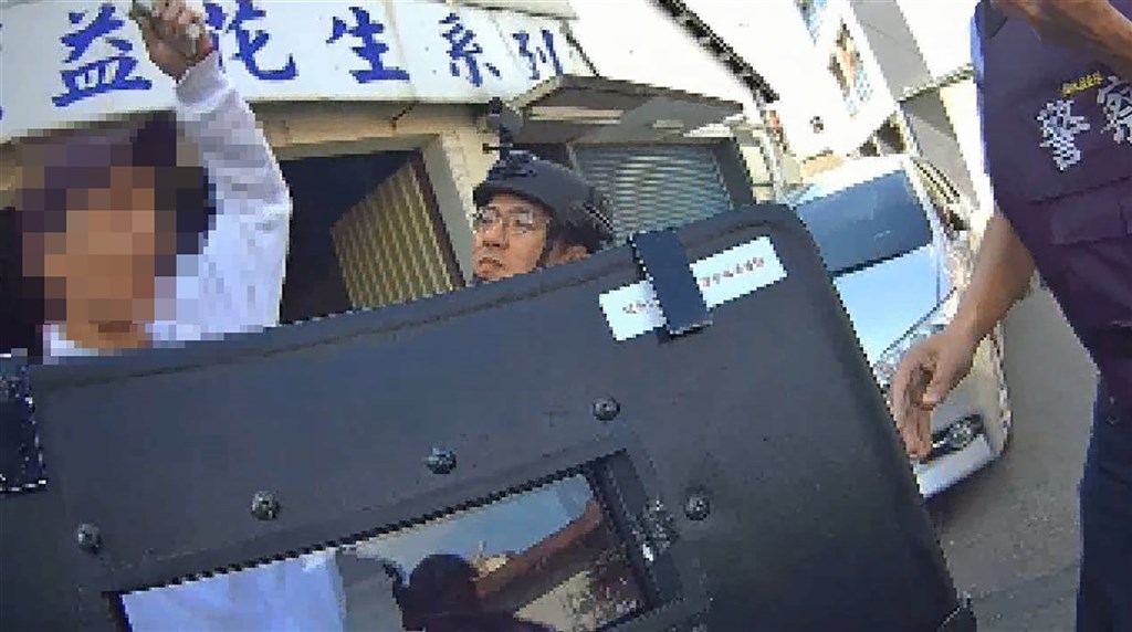 周姓男子在彰化縣某平房內私造槍枝、子彈及爆裂物遭警方圍捕。圖為民國113年2月周男手持遙控器威脅引爆爆裂物與警方對峙。（警方提供）