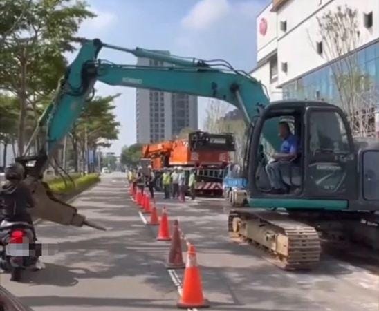 怪手將破碎鑿頭橫在馬路中間阻擋機車騎士。 圖：翻攝自爆料公社