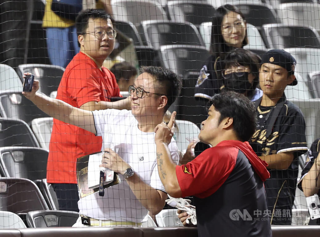 中職味全龍隊一連3天在台北大巨蛋替「大師兄」林智勝舉辦引退系列賽「31CONIC 智勝一擊」，7日賽前林智勝（前）打擊練習結束後，與本壘後方球迷合影。 圖：中央社記者張新偉/攝