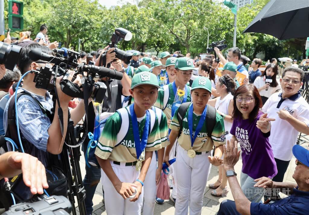 選手們在民眾夾道歡迎中出發前往台北大巨蛋。 圖：中央社記者張皓安/攝