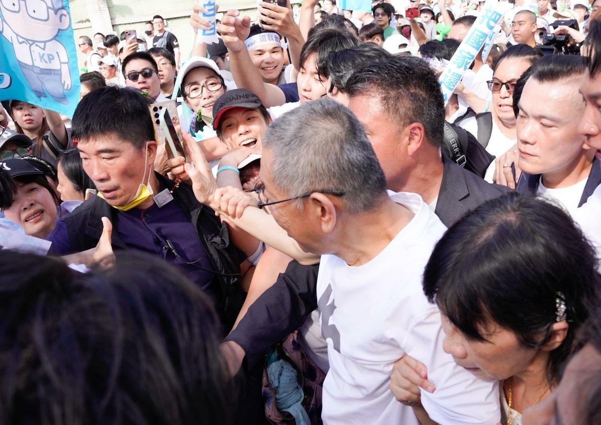 前民眾黨主席柯文哲在小草簇擁下走上座車。 圖：張良一/攝