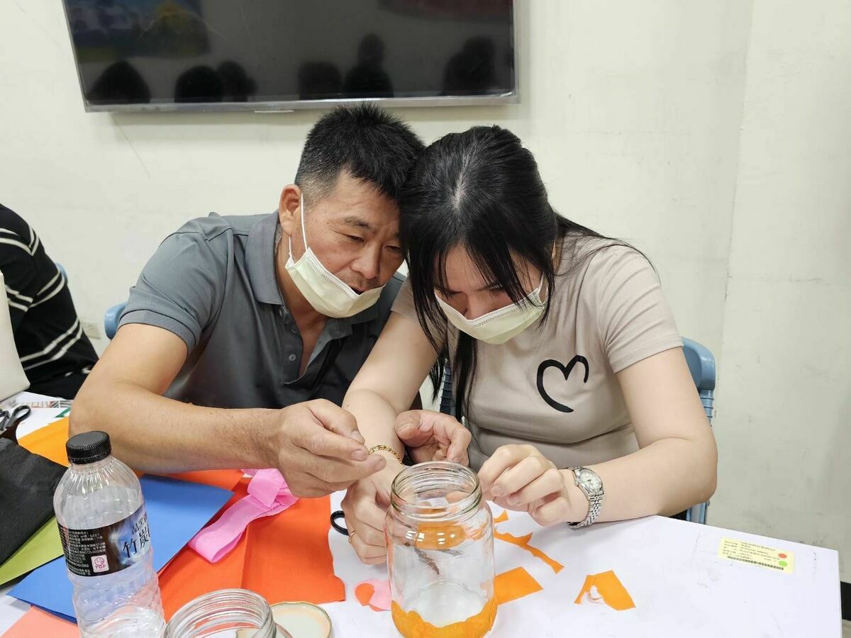 童德鴻帶領新住民夫妻利用回收玻璃瓶製作家飾燈，透過光影傳遞感受感恩與互助。 圖：移民署台中第二服務站/提供