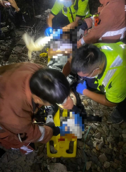 救護人員耗時20分鐘將卡在車底的男子救出，發現男子左腳掌斷裂，右手肘也嚴重變形。 圖：消防局提供