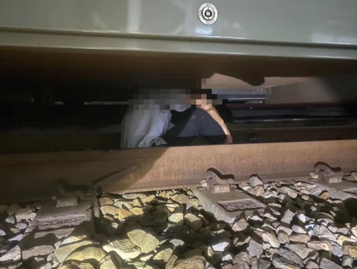 男子因不明原因落軌，隨即遭迎面的列車撞擊，卡在車底。 圖：消防局提供