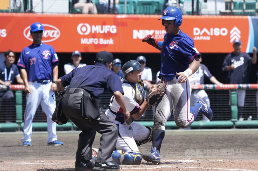 U18世界盃棒球賽季軍戰台灣14日與韓國交手，台灣隊5局上靠著攻勢串連攻下2分超前，6局下再被韓國扳平比數，7局上有插曲，曾聖恩（右）跑回本壘被判出局，經過重播輔助判決改判阻擋得分。中央社記者徐肇昌沖繩攝 114年9月14日