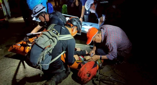 登山客遭台灣大虎頭蜂襲擊，後續由救援人員以擔架接駁下山。 圖：苗栗縣政府消防局提供