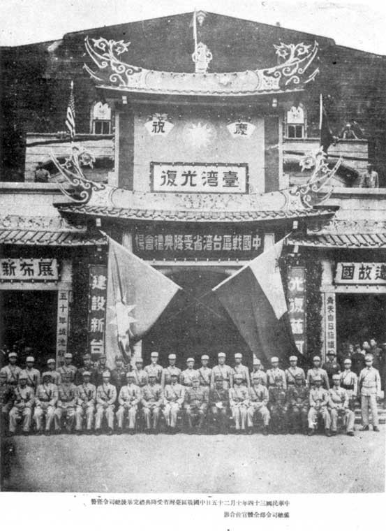 1945年10月25日，臺北公會堂舉行「中國戰區臺灣省受降典禮」後，臺灣省警備總司令部全體官兵合影。左半邊掛中國國民黨黨旗，右半邊掛中華民國國旗。 圖：翻攝維基百科/Howard61313/公有領域