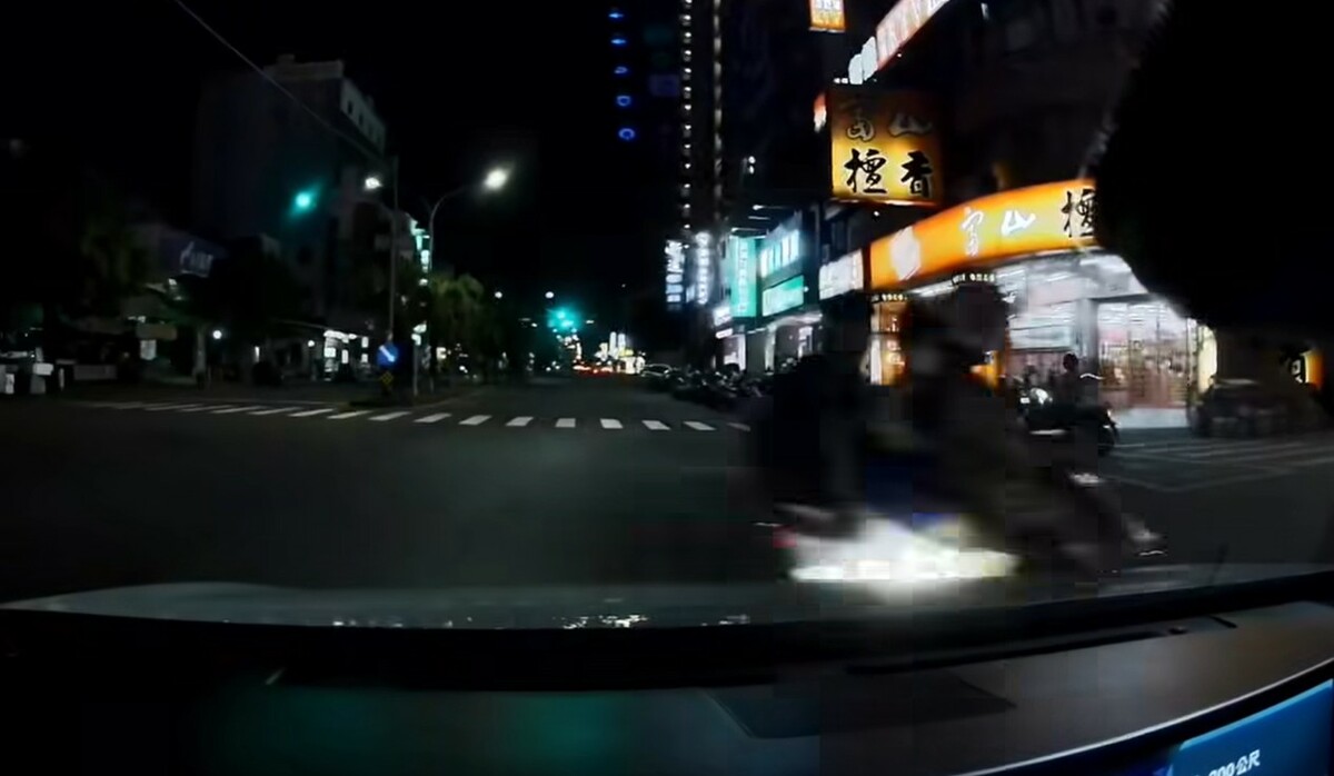 高雄婦人載2孩童騎車闖紅燈，險遭汽車撞上。 圖：翻攝自臉書高雄大小事