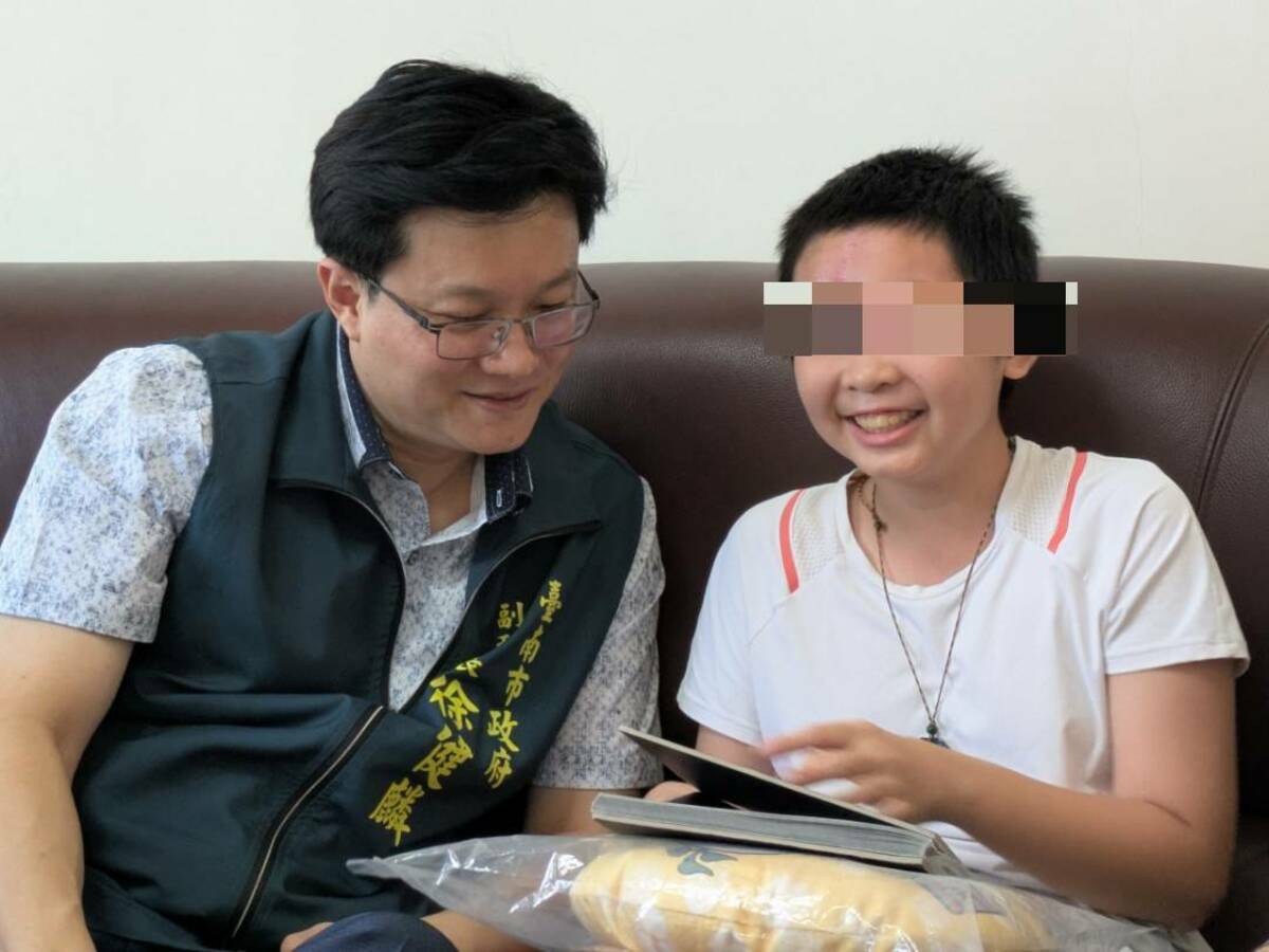 小如開心地拿自己手繪的漫畫跟徐健麟分享。 圖：台南市政府提供
