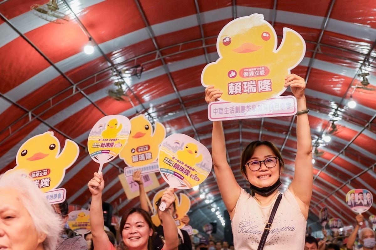 支持者高舉小鴨手牌，肯定他在新聞局長任內行銷高雄。 圖：賴瑞隆服務處/提供