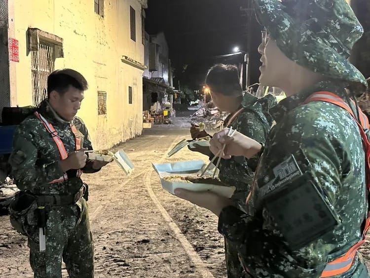 國軍弟兄就地用餐與休息，每人都滿臉塵土。 圖：軍方提供