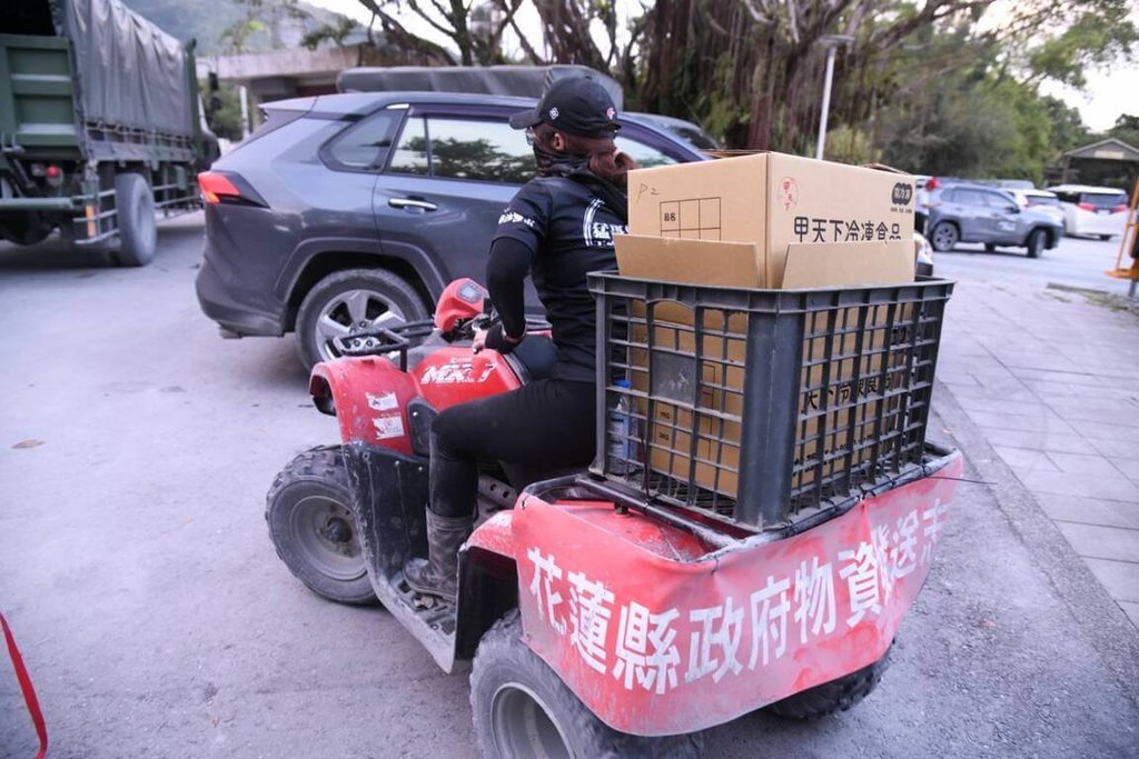 花蓮馬太鞍溪堰塞湖溢流重創光復鄉，由於街道泥濘不堪、機具難以進入，29日一輛輛懸掛「花蓮縣政府物資發放志工」紅布條，滿載便當與物資的沙灘車陸續駛入災區。（花蓮縣政府提供）