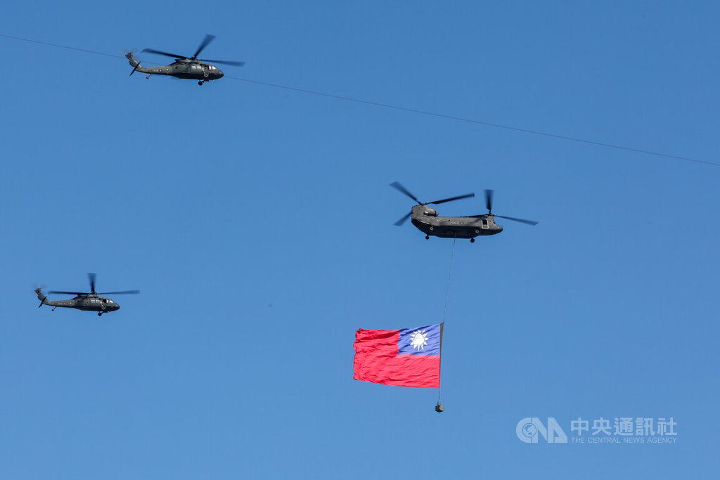 雙十國慶將至，國慶籌備委員會6日在總統府前為114年國慶大會進行預演，國軍CH-47契努克直升機（右）在國歌領唱時吊掛巨幅國旗，飛越府前上空。 圖：中央社提供