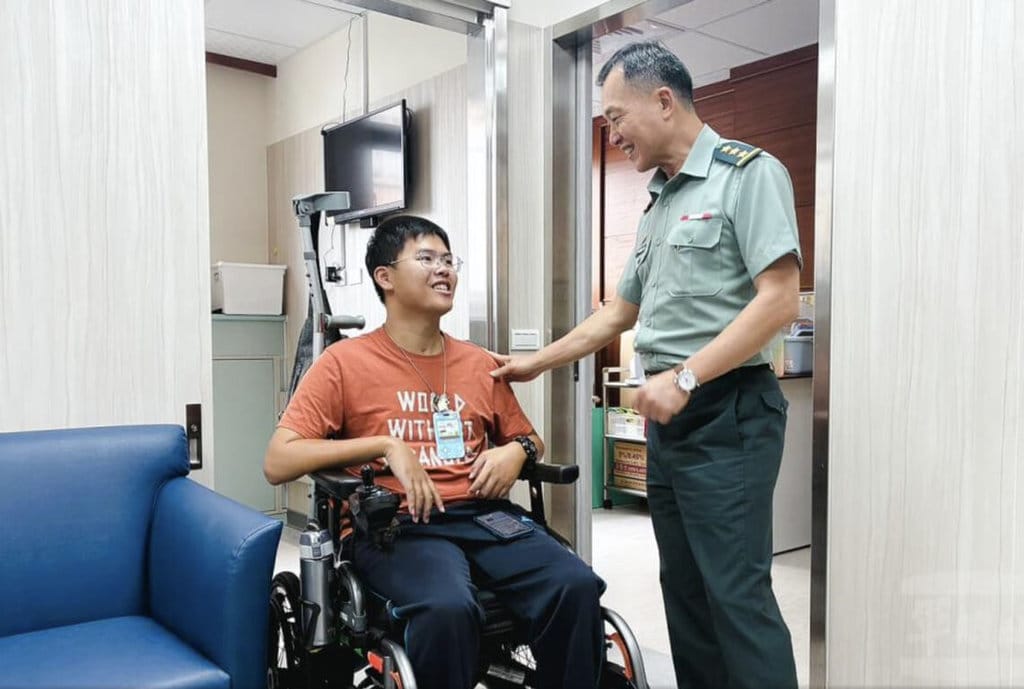 傘兵秦良丰（左）民國107年跳傘時重傷，事後憑藉驚人意志力存活，鼓舞各界，並在去年退伍任職軍醫院，國防部副部長鍾樹明上將（右）3日前往慰勉。 圖：軍聞社提供