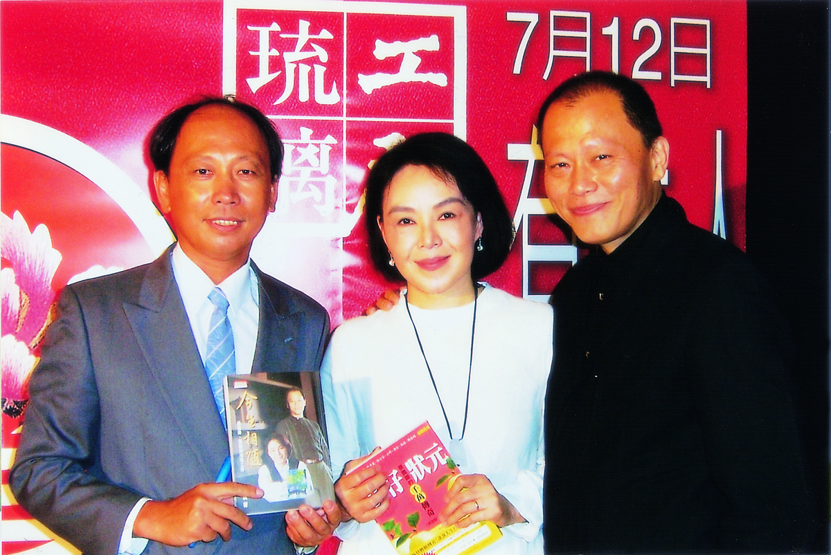 蔡國顯(左)特別北上信義計畫區新光百貨祝賀張毅(右)、楊惠姍(中)琉璃工坊20周年展覽。楊惠姍手中的書即為蔡國顯的自傳式著作《拔仔狀元》，由她和張毅二人幫忙寫序推薦，張毅也一直有意將《拔仔狀元》拍成電影，蔡國顯則手拿琉璃工房的故事書「今世相隨」，足見雙方的好交情。 圖：蔡國顯/提供