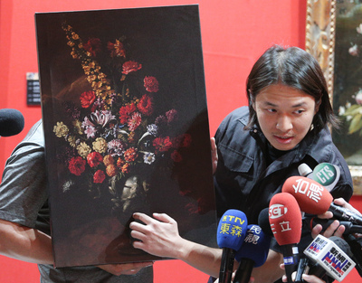 義大利畫家保羅．波爾波拉的油彩畫「花」來台展出，被12歲男童意外壓破一個洞，國內知名修復師蔡舜任（圖）拿著圖說明畫作受損情形。圖：中央社