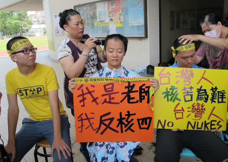 高師大學生活動中心廣場設有公投連署攤位，中午有性別研究所助理教授楊佳羚（前中）等7名師生以剃髮宣示他們反核、要求停建核四的立場。圖：中央社