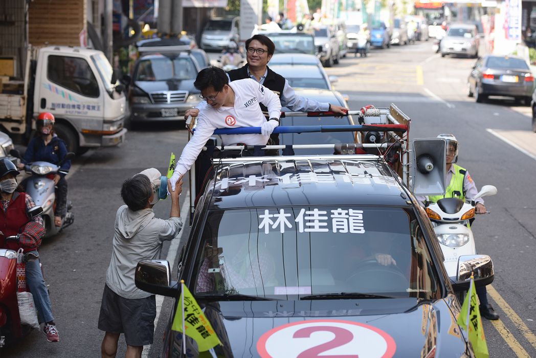 林佳龍21日到西屯區掃街，對選舉公報刪除他的部分政見表達不滿。圖：林佳龍辦公室提供。