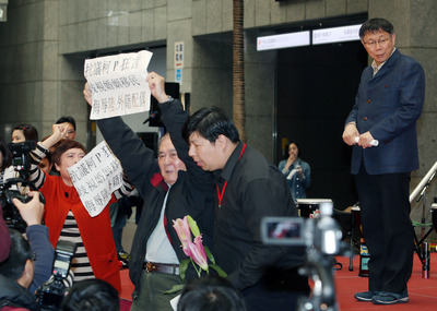 台北市長柯文哲「進口外籍新娘」說引發爭議，8日下午出席「幸福女人調感恩音樂會」時，有民眾現場舉牌抗議。圖：中央社