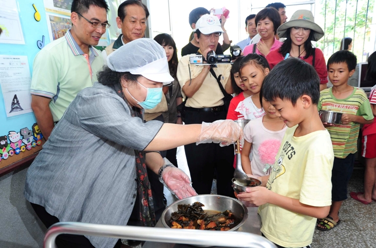 高雄市長陳菊為學童打菜，也有模有樣。圖片來源：高雄市政府