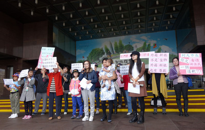 台北市長柯文哲「進口外籍新娘」說引發爭議，台北市新移民女性關懷協會的10幾名外籍配偶成員，8日帶著孩子前往北市府門口抗議。圖：中央社