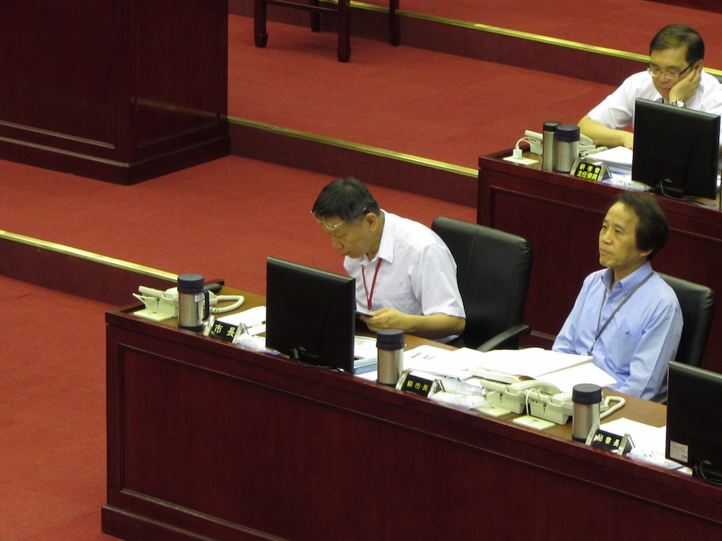 柯文哲收下後回到座位上，還頻頻翻開故事書認真閱讀。