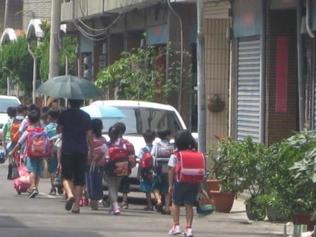 圖是學童學校放學不回家，由安親班教師帶到安親班，沿路經過住宅區的情形。圖片來源:陳志科攝