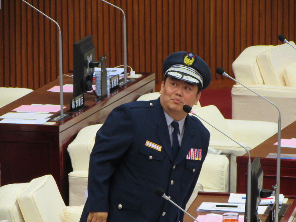 國民黨台北市議員陳重文8日特地穿上義警制服，要求台北市府將義交、導護志工與社區巡守隊都納入護童專案。圖：邱珮文/攝