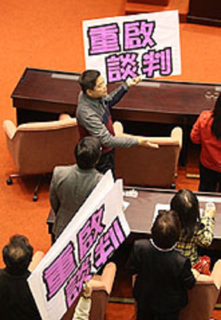 面對美方不斷施壓，立法院5日仍三讀通過反美牛修法，民進黨籍立委拿著自製看板，表達盼重啟談判的立場。圖片來源：中央社