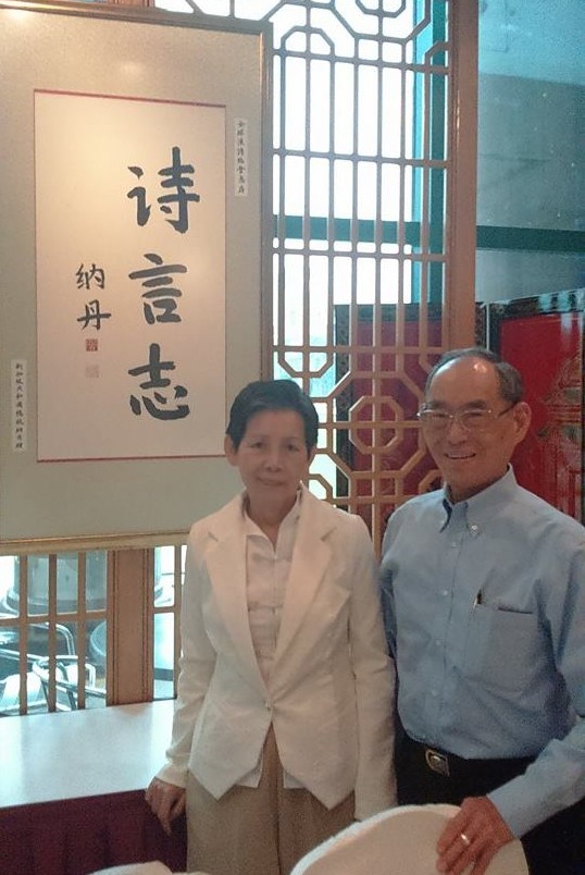 來自台北大稻埕、成為新加坡「建國一代」的張兼嘉夫婦站在自家餐廳二樓，牆上掛的是那丹總統的書法題字「詩言志」。圖：黃瓊雅/攝