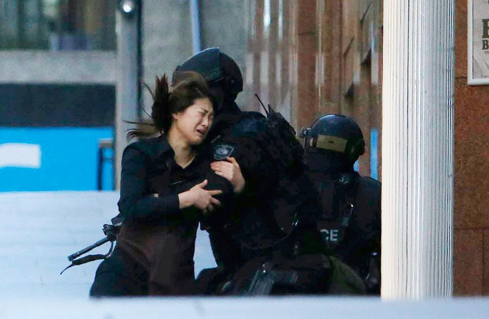 澳洲警方在槍手所在的咖啡庭外嚴陣以待，稍早時間部分人質從咖啡廳內逃出。圖片來源：達志影像/路透社。