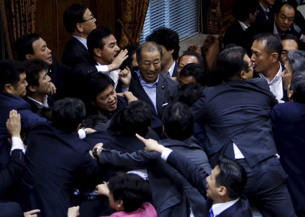 日本議員在參議院進行表決時，圍繞在特別委員會主席鴻池祥肇旁，場面混亂。圖片來源：達志影像/路透社