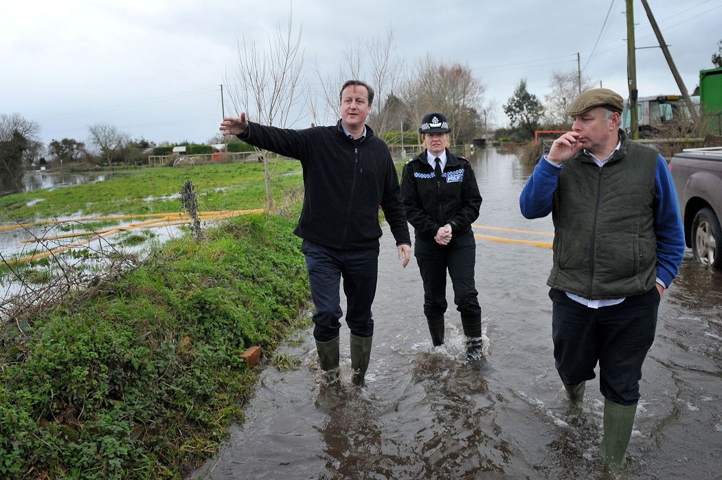 英格蘭西南部地區及威爾斯豪雨成災，英國首相卡麥隆罕見地取消了中東訪問行程，並承諾在救災方面，「錢不是問題」。圖為卡麥隆前往災區視察。圖片來源：達志影像/美聯社