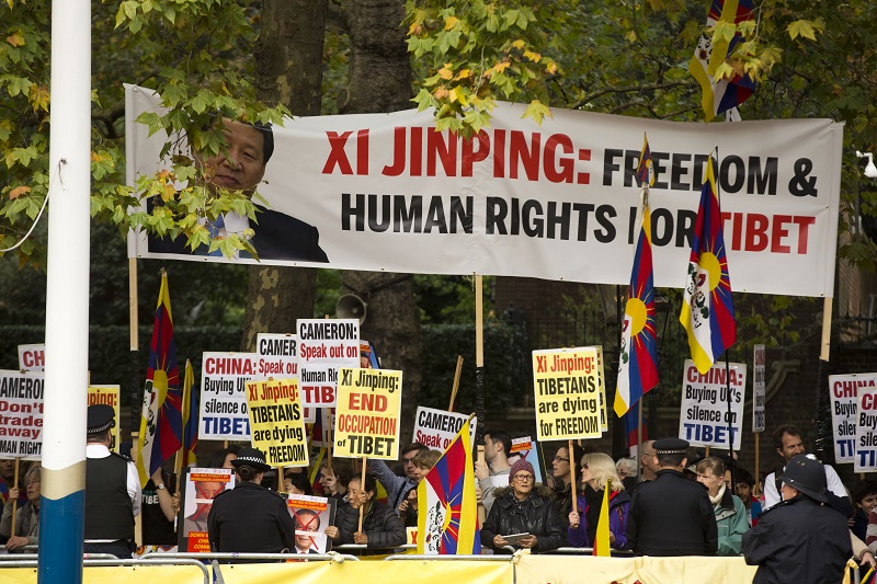 人權團體與支持西藏的抗議人士揮舞抗議標語、高分貝抗議習近平訪問英國。圖片來源：達志影像/美聯社