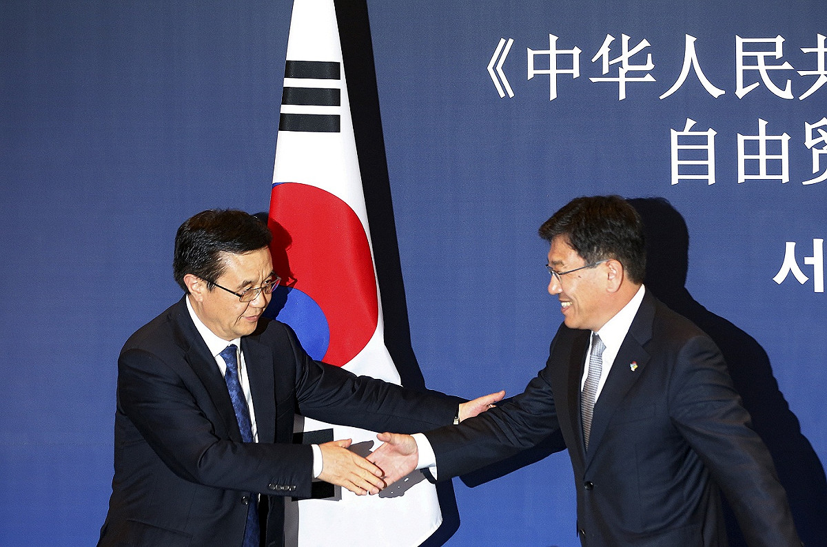 韓國與中國2015年1日正式簽署自由貿易協定（FTA），由韓國產業通商資源長官尹相直（右）和中國商務部部長高虎城（左）在首爾舉行簽署儀式。 圖：達志影像/路透社