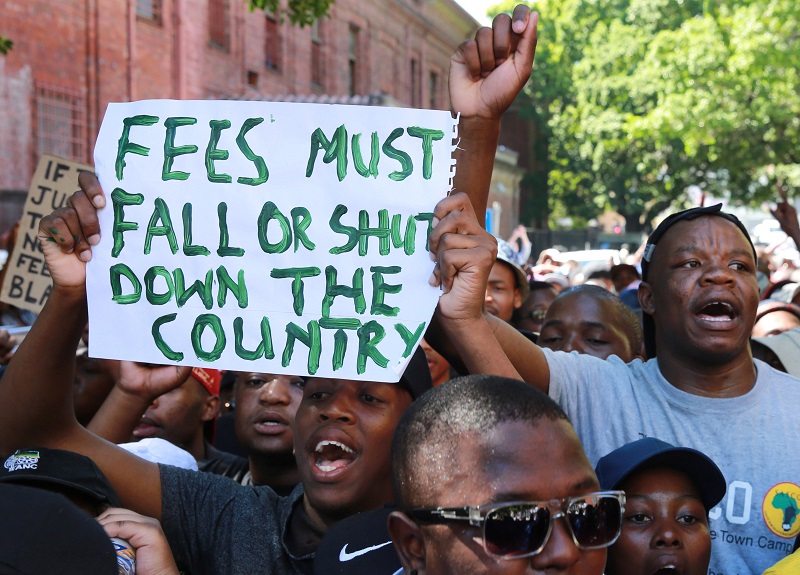 抗議大學學費大幅調漲，南非學生走上街頭，高舉「學費必降」（Fees Must Fall）紙板怒吼。圖片來源：達志影像/美聯社