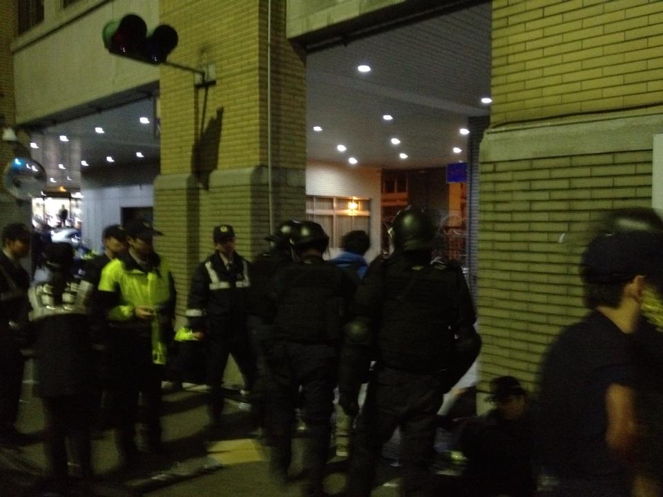 占據行政院行動的總指揮魏揚（圖中穿藍色衣服）今(24)日4點56分被20幾名霹靂小組警察包圍，並由3名警察上銬帶走，送至保安大隊。圖：沈發惠提供
