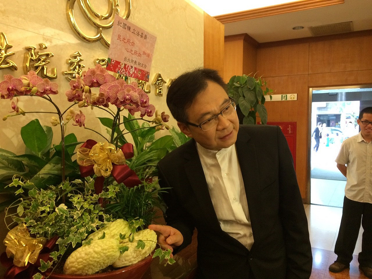 紀國棟指著台北市長柯文哲送的「苦瓜花」說，相信未來情勢會像苦瓜一樣，苦盡甘來。圖：符芳碩/攝