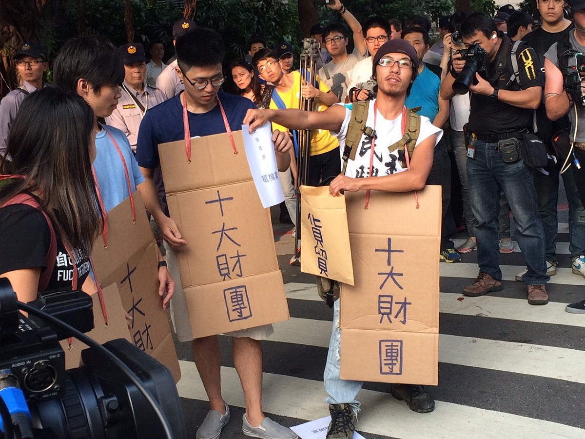 民眾舉著抗議紙牌。圖：符芳碩/攝