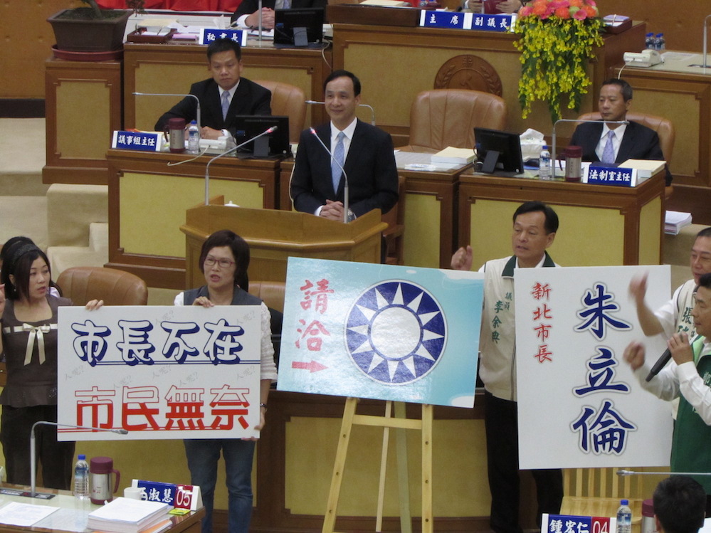 國民黨主席朱立倫3日指出，17日他將親自主持中常會，沒有問題。圖為新北市議會總質詢首日，民進黨議員諷刺新北市民要在國民黨中央黨部才能找到朱立倫。圖：邱珮文/攝