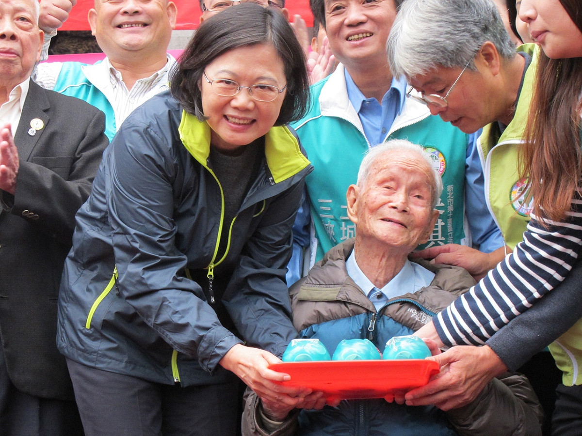 民進黨總統候選人蔡英文11日在三峽祖師廟接受108歲人瑞林（不直）阿公贈送3隻小豬撲滿。圖：林朝億/攝