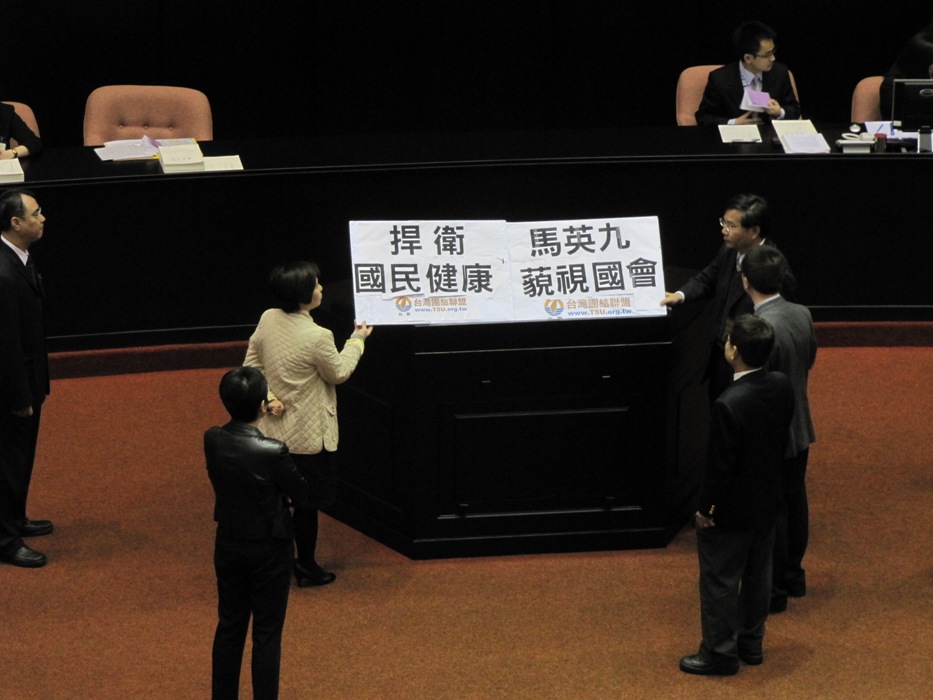 因為瘦肉精美牛議題，台聯許忠信、林世嘉與黃文玲3位立委今（6）日以舉牌霸佔主席台、杯葛議事，導致總質詢無法開始，立院再度陷入空轉。圖片：謝莉慧/攝
