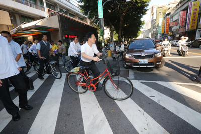 江宜樺與隨扈一起騎腳踏車，8時來到住家附近的河堤國小投票，引起民眾好奇。圖：中央社