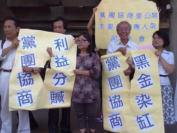 公督盟25日於記者會現場演出小型行動劇，戳破寫有抗議標語「黨團協商、利益分贓」及「黨團協商、黑金染缸」的大字報，表示希望破除黨團協商制度。圖：賴義中/攝