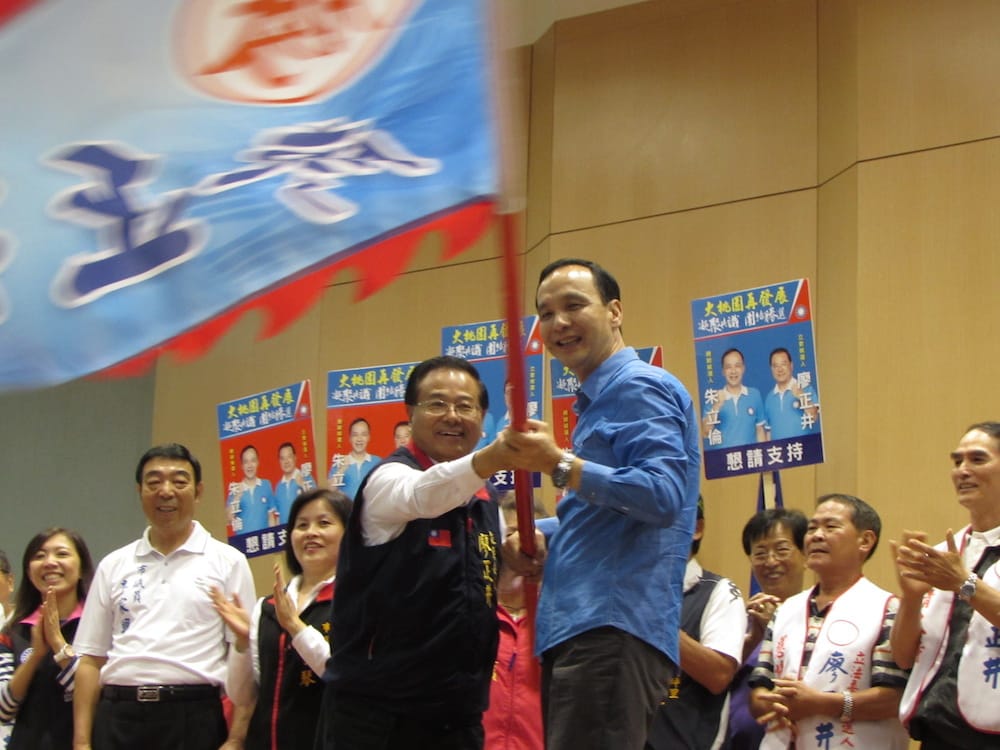 國民黨總統參選人朱立倫27日與立委參選人廖正井出席桃園市農漁水利團體造勢活動，兩人一同揮舞「戰旗」。圖：邱珮文/攝