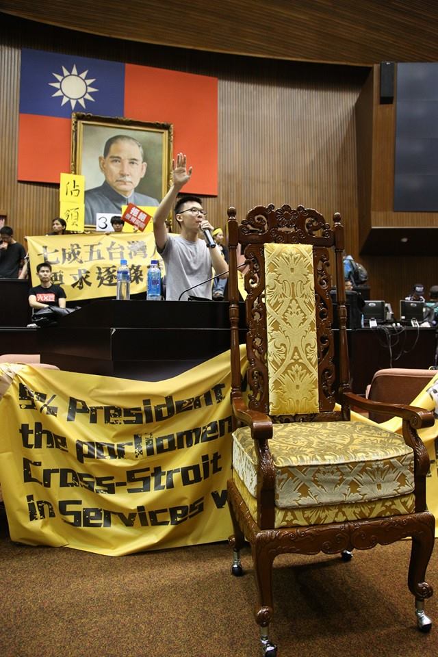 抗議學生把王金平的椅子搬出來，林飛帆在主席台前以會議主席身分宣布，服貿審查會議開始，現場響起歡呼聲。圖2之1： 圖：林雨佑/攝