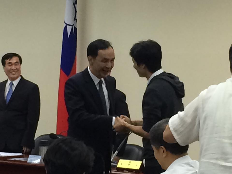 國民黨主席朱立倫獲百大青農盧紀燁贈建言書與老鷹羽毛，象徵祝福蛻變。圖：劉彥彤/攝