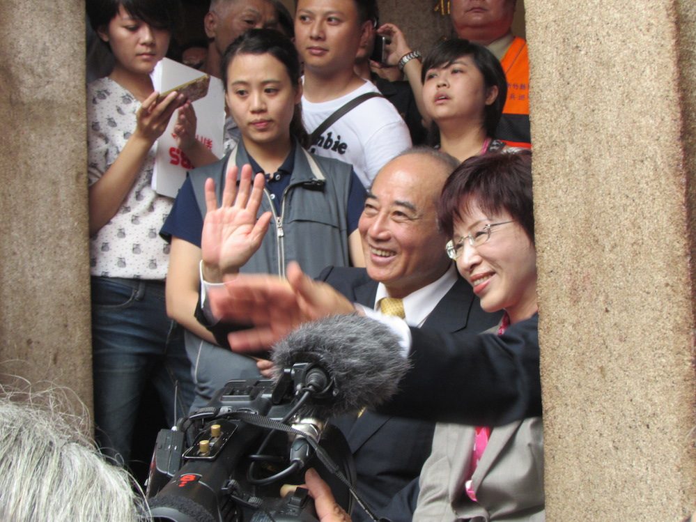國民黨總統參選人洪秀柱與民進黨參選人蔡英文2日出席義民節活動，2度握手致意。圖為立法院長王金平向坐在對面的蔡英文揮手致意，蔡也微笑揮手回應。圖：邱珮文/攝